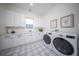 Bright laundry room with white cabinets, checkerboard floor, and modern appliances at 2420 Floyd St, Sarasota, FL 34239