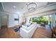 Spacious living area featuring light hardwood floors, white sofas, and access to outdoor space at 2420 Floyd St, Sarasota, FL 34239