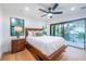 Bright bedroom with wood floors, a king bed, and sliding glass doors leading to a balcony at 2440 Floyd St, Sarasota, FL 34239