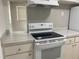 White kitchen with a stove, countertop and cabinets at 2825 Sequoia Ln, Sarasota, FL 34237