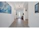 Long entry hallway with light hardwood floors and coastal decor at 5415 Limelight Dr, Apollo Beach, FL 33572