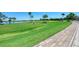 Golf course with lush green grass, palm trees, and a player putting at 7607 Grand Estuary Trl # 205, Bradenton, FL 34212