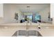 Kitchen sink overlooking living room with modern chandelier at 7607 Grand Estuary Trl # 205, Bradenton, FL 34212