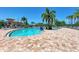 Expansive resort-style pool surrounded by palm trees and lounge chairs at 7607 Grand Estuary Trl # 205, Bradenton, FL 34212