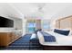 Bright bedroom featuring blue-striped carpet, a ceiling fan, and ocean views from the balcony at 240 Sands Point Rd # 4507, Longboat Key, FL 34228