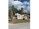 Tan single-story home with red door, palm trees, and fenced yard at 3375 8Th St, Sarasota, FL 34237