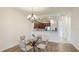 Dining area with glass table, four chairs, and a view into the kitchen at 12508 Garibaldi Ln, Venice, FL 34293