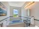 Bathroom with tub, pedestal sink, decorative tile border and view from window at 5444 Gulf Of Mexico Dr, Longboat Key, FL 34228