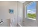 Bright bathroom featuring a white tub with tile surround and window with natural light at 5444 Gulf Of Mexico Dr, Longboat Key, FL 34228