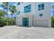 Modern home featuring a gravel driveway, palm trees and a blue glass railed balcony over the entrance at 5444 Gulf Of Mexico Dr, Longboat Key, FL 34228