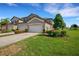 Two-car garage, paver driveway, and manicured lawn at 5830 Wake Forest Run # 104, Bradenton, FL 34211