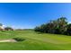 Green golf course with sand trap and palm trees under a clear sky at 7112 Marsh View Ter, Bradenton, FL 34212