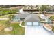 Aerial view of a light teal house with a three-car garage, boat, and shed at 613 Elba Dr, Nokomis, FL 34275