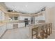 Spacious kitchen featuring white cabinets, stainless steel appliances, and breakfast bar at 974 Rotonda Cir, Rotonda West, FL 33947