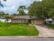 Ranch-style home features a stone facade, lush lawn, and a driveway at 4218 Vaughan Ln, Sarasota, FL 34241