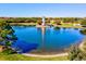 Scenic aerial view of community lake with decorative lighthouse, trees, and green space at 105 New Briton Ct, Bradenton, FL 34212