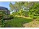 Lush backyard featuring green lawn, manicured hedges, and mature trees creating a private outdoor space at 105 New Briton Ct, Bradenton, FL 34212