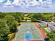 Aerial view of full sized basketball court with parking and surrounded by mature trees at 105 New Briton Ct, Bradenton, FL 34212