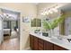 Bathroom boasts double sinks, decorative plants, a bright mirror, and natural light to create a fresh and inviting atmosphere at 105 New Briton Ct, Bradenton, FL 34212