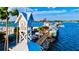 Scenic view of the waterfront featuring a clock tower, pier shops, palm trees, and boats under a sunny sky at 105 New Briton Ct, Bradenton, FL 34212