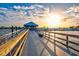 Stunning view of a pier extending into the water, with a building at the end and a bright sun in the sky at 105 New Briton Ct, Bradenton, FL 34212