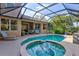 Backyard pool and hot tub featuring a screened enclosure and complemented by tropical landscaping at 105 New Briton Ct, Bradenton, FL 34212