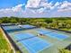 Aerial shot of community tennis courts with abundant trees and landscaping surrounding at 105 New Briton Ct, Bradenton, FL 34212