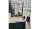 Bathroom with a dark vanity, undermount sink, and a wood framed mirror at 3220 Valencia Rd, Venice, FL 34293