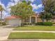 Charming home featuring a well-manicured lawn, mature trees, and a stylish light blue front door at 3108 Royal Palm Dr, North Port, FL 34288