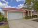 Exterior shot of the home showing the garage with a white door and a neatly landscaped yard at 3108 Royal Palm Dr, North Port, FL 34288