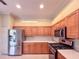 Well-lit kitchen featuring stainless steel appliances, wooden cabinets, and modern fixtures at 3108 Royal Palm Dr, North Port, FL 34288