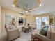 Staged living room with a ceiling fan, stylish furniture, and a view of the backyard through sliding glass doors at 3108 Royal Palm Dr, North Port, FL 34288