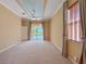 Bright main bedroom features neutral carpet, tray ceiling with fan, and sliding doors to the pool at 3108 Royal Palm Dr, North Port, FL 34288