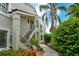 Townhouse exterior featuring a walkway, stairs, and tropical landscaping at 7673 Fairway Woods Dr # 706, Sarasota, FL 34238