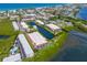 Aerial view of waterfront community with lush landscaping, tennis courts, and a pool at 3705 E Bay Dr # 115, Holmes Beach, FL 34217