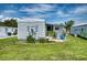 White mobile home with a small patio and grassy yard at 6428 Fleetwood Ct, North Port, FL 34287