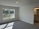 Main bedroom with gray carpeting, large window, and access to en-suite bathroom at 8005 Tropicaire Blvd, North Port, FL 34291