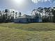 Side view of a new single-story house with gray siding, gray roof and a grassy yard at 8005 Tropicaire Blvd, North Port, FL 34291