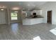 Open kitchen with white cabinets, granite countertops, and gray wood-look tile floors at 8005 Tropicaire Blvd, North Port, FL 34291