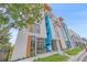 A striking modern townhome with colorful accents stands out against a blue sky and lush greenery at 1558 4Th St # 216, Sarasota, FL 34236