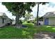 Landscaped backyard with mature trees and a green lawn at 2517 Glebe Farm Close # H-2, Sarasota, FL 34235
