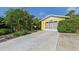 Bright yellow house with a garage and well-maintained landscaping at 1248 Jefferson Dr, Englewood, FL 34224