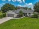 Single-story home with gray roof, attached garage, and landscaped yard at 13609 3Rd E Ave, Bradenton, FL 34212