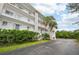 Exterior view of condo building showcasing landscaping and parking at 1401 S Mccall Rd # 108A, Englewood, FL 34223