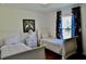 Bright twin bedroom featuring two beds with patterned accents and a large window at 221 Evergreen St, Punta Gorda, FL 33982