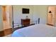 This is a charming bedroom with a TV, wood floors, and a view into the bathroom at 221 Evergreen St, Punta Gorda, FL 33982