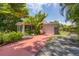 Charming home featuring a colorful driveway, lush tropical landscaping, and a light-colored facade at 839 40Th St, Sarasota, FL 34234