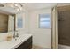 Clean bathroom with dark vanity, shower, and two windows at 2216 Lee Ln, Sarasota, FL 34231