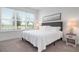 Cozy bedroom with plush carpet, view of pond, soft natural light, and stylish nightstands at 5709 Puccini St, Nokomis, FL 34275