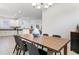 Bright dining room featuring wood table, modern chandelier and neutral decor, adjacent to kitchen area at 5709 Puccini St, Nokomis, FL 34275